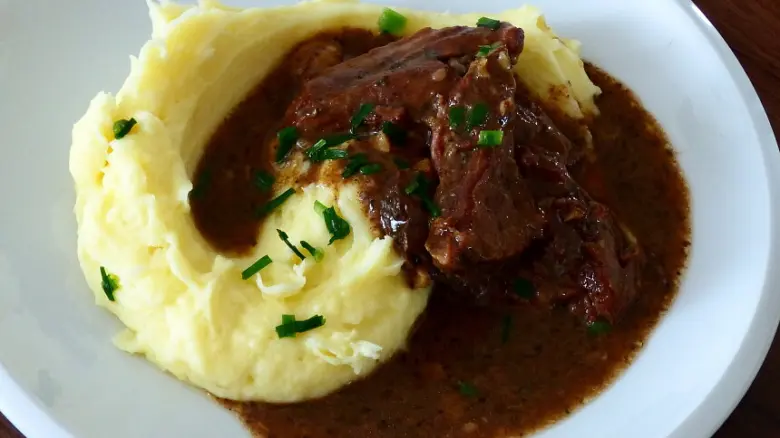 Hotová hovězí kližka podávaná s bramborovou kaší.