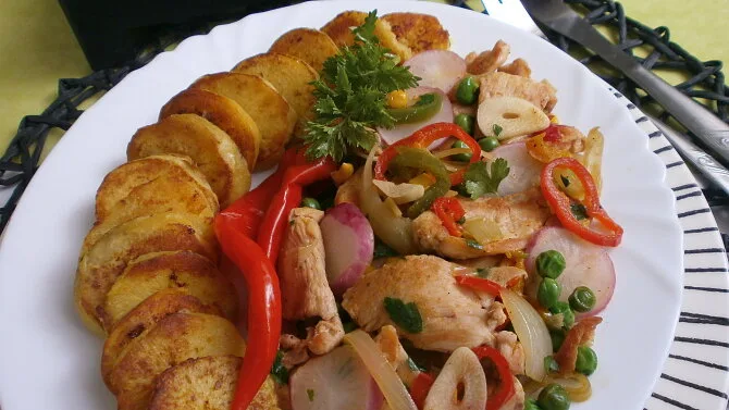 Příprava kuřecího masa se zeleninou a smaženými bramborami.