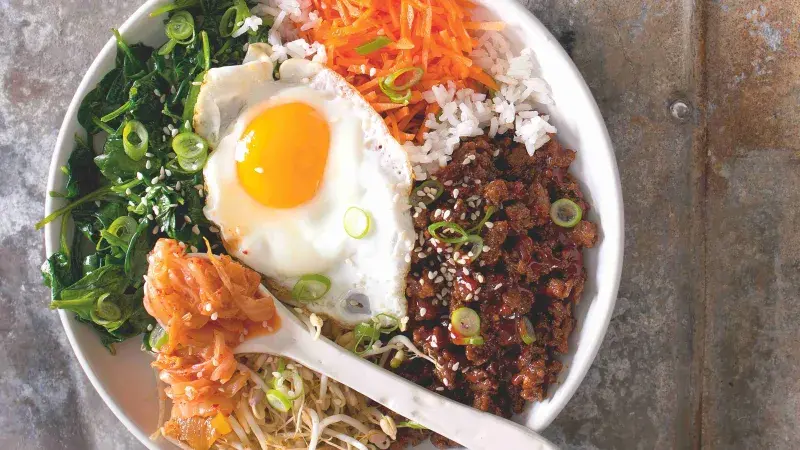 Bibimbap s vejcem, zeleninou a korejským kimčím.