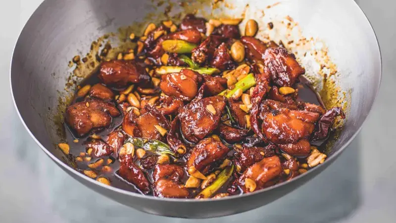 Hotovo kuřecí kung pao s arašidy v hluboké pánev.