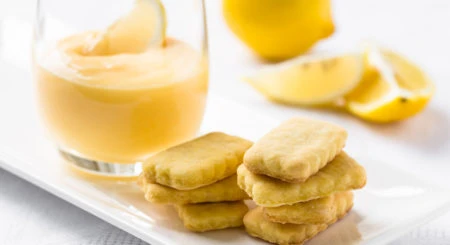 Citronové sušenky s nápojem na bílém talíři.