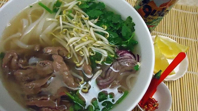 Miska vietnamské polévky pho s masem a zeleninou.