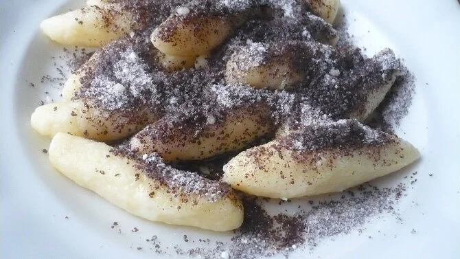 Připravené bramborové šišky s cukrem a mákem na talíři.