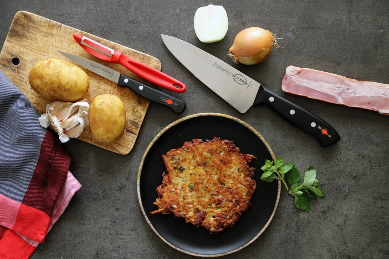 Hotové bramborové placky s surovými ingrediencemi kolem.