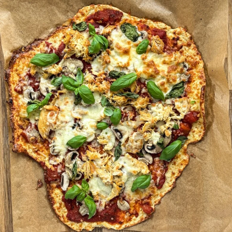 Domácí pizzy s houbami a bazalkou na pečicím papíru.