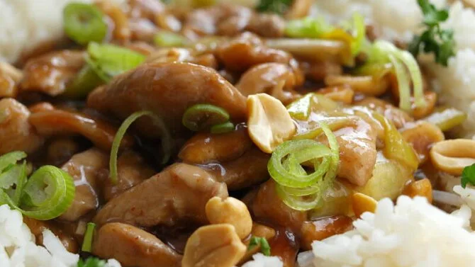 Hotovo kuřecí kung pao s rýží, oříšky a cibulkou.