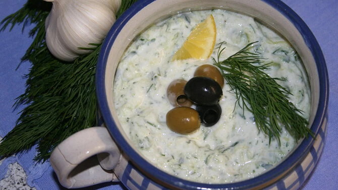 Miska s tzazikim ozdobená olivami citronem a koprem.