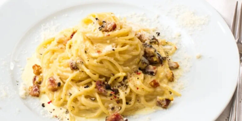 Smetaná špagety carbonara s křupavým pancettou a parmazánem.