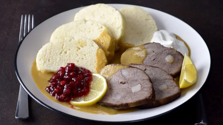 Porce s omáčkou a knedlíky na talíři