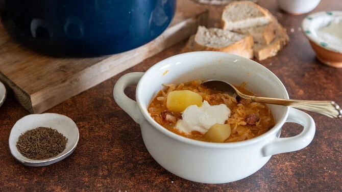 Miska zelňačky s klobásou, bramborami a zakysanou smetanou.