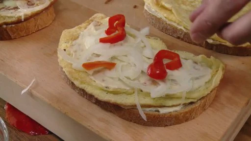Kousek chleba s vejcem, cibulí a paprikou na přípravy smaženky.