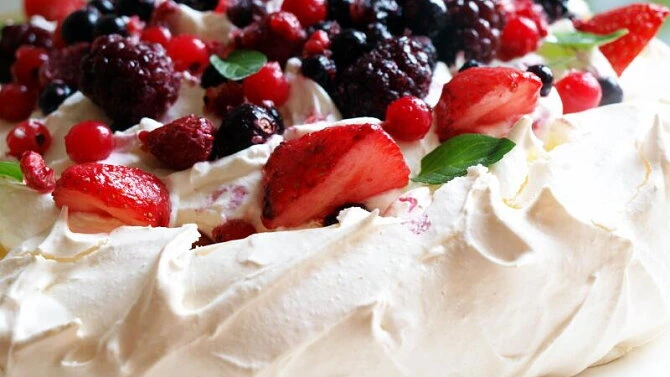 Dort pavlova s čerstvými jahodami a malinami na smetaně.