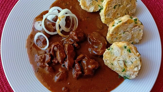 Použitý recept na dančí guláš s kousky masa, cibulí a pečenými plackami.