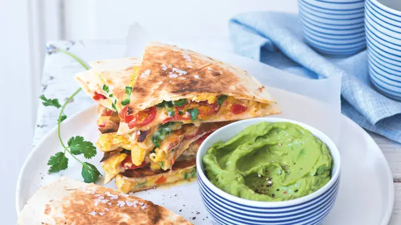 Skládané quesadilly z tortilly s vejci, zeleninou a dipem z avokáda.