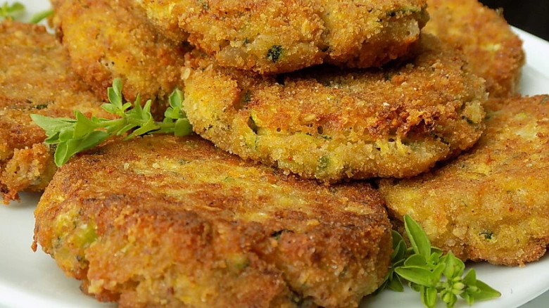 Zlaté karbanátky ze cukety bez masa na bílém talíři.