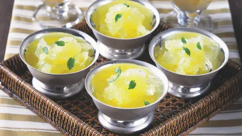 Čtyři stříbrné šálky s citronovým sorbetem ozdobené máty.
