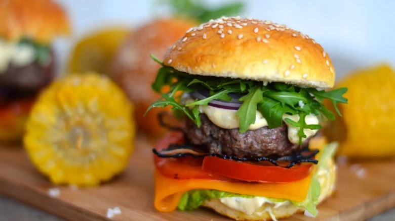 Hovězí hamburger s listovým salátem, rajčetem a slaninou.