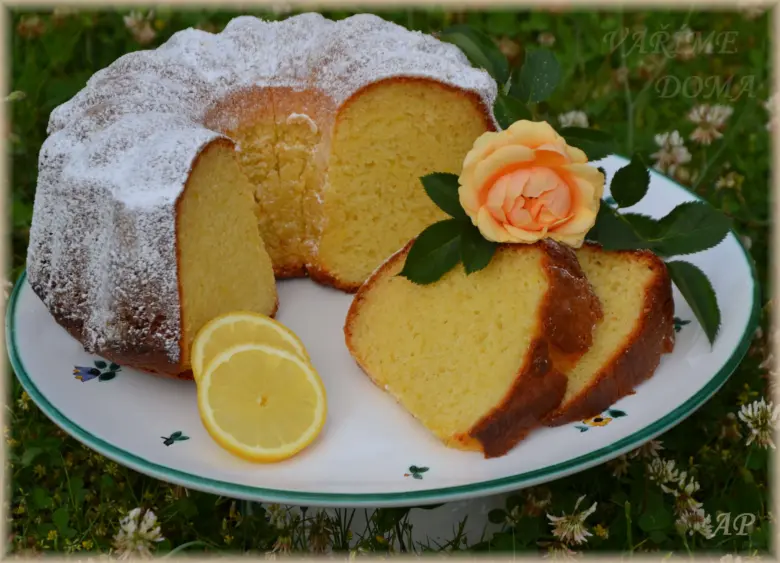 Citronová bábovka s jogurtem na talíři se šlehanou citronovou kůrou.