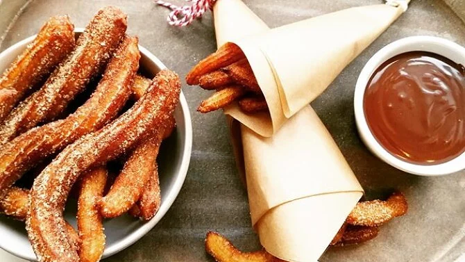 Kone s čirosovémi churrosovými tyčinkami v misce.