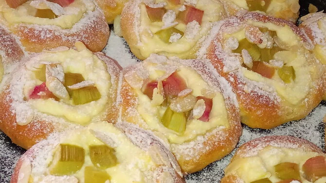 Kynutý koláč s tvarohem a rebarborou posypaný cukrem.