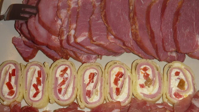 Sýrová roláda nakrájená na plátky s náplní z tvarohu a papriky.