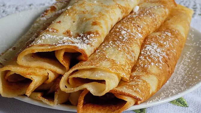 Zlaté palačinky s cukrem na talíři