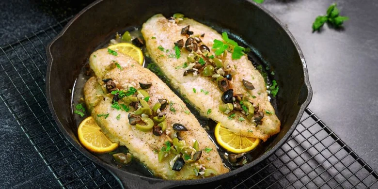 Pangasius na pánvi s citronem, kaparysy a petrželkou.