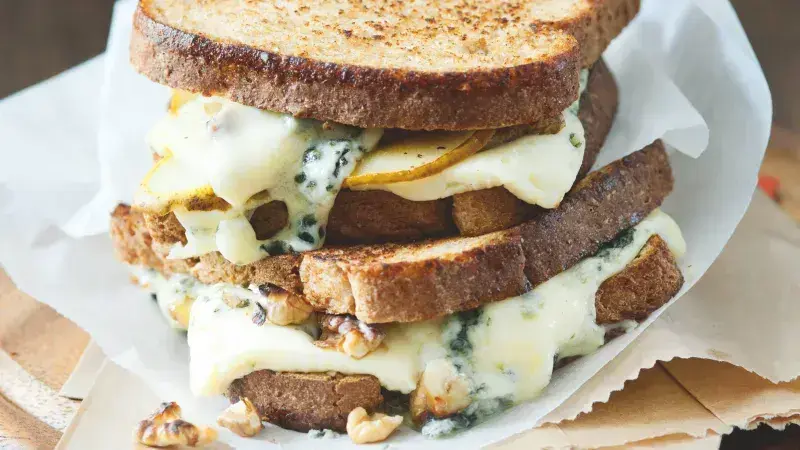 Zapečený toast s modrým sýrem, vlašskými ořechy a kousky hrušky.