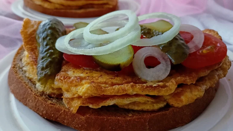Smaženka s vejcem, okurkou, cibulí a rajčetem na chlebu.