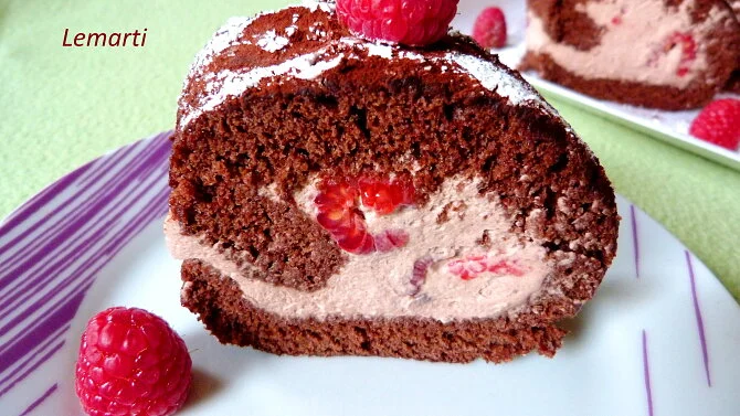 Kousek čokoládové rolády s malinami a mascarpone na talíři.