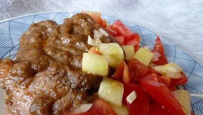 Maso s tatarskou omáčkou z rajčat a jablek na talíři.