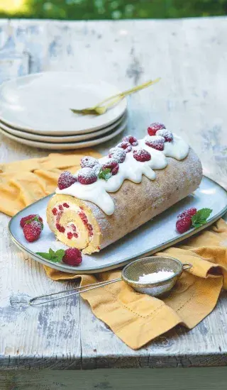 Překrásná roláda s mascarpone, malinami a cukrem na talíři.