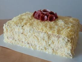 Hotový slaný dort s uzeným masem na vrchu.