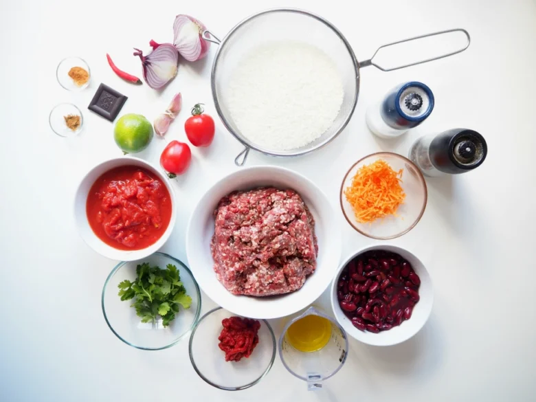 Suroviny pro recept na chilí kon karne: maso, rajčata, fazole.