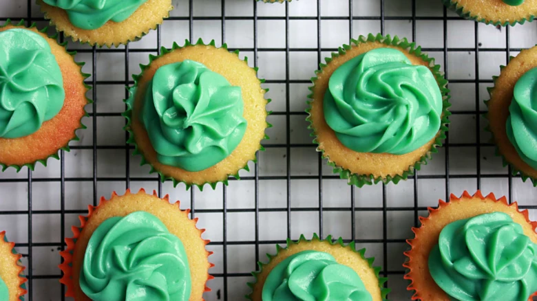 Zelené krémy na muffiny s listovou dekorací.