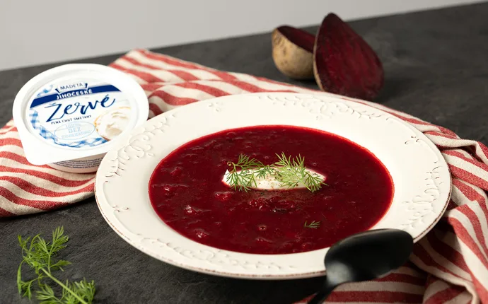 Červená řepová polévka s kysanou smetanou a petrželkou.