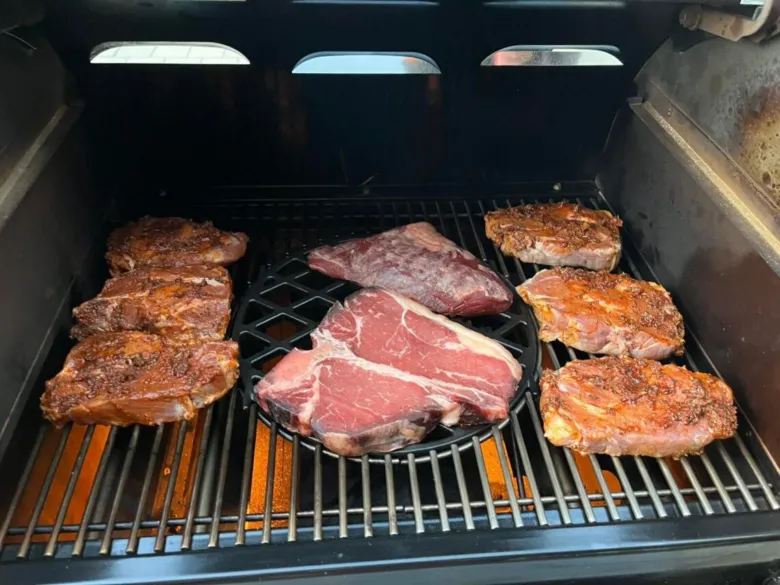 Kusky krkovice se uvaří na mřížce v otevřeném grilu.