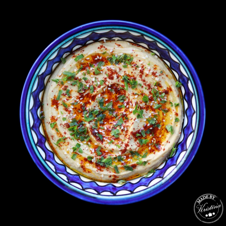 Domácí hummus z cizrny s čerstvou petrželkou a sezamem.