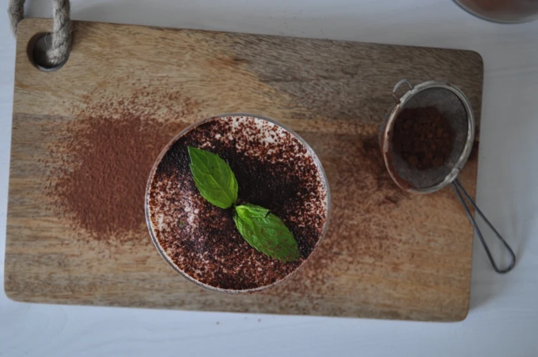 Hotový dezert Tiramisu s čokoládou na dřevěném prkénku.