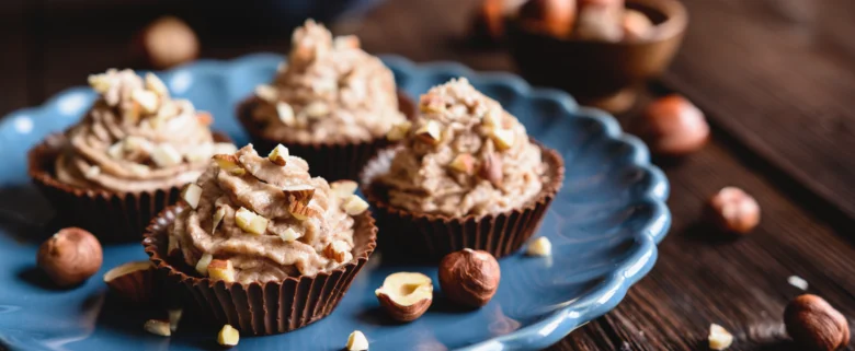Čokoládové muffiny s ořechy na modrém talíři.