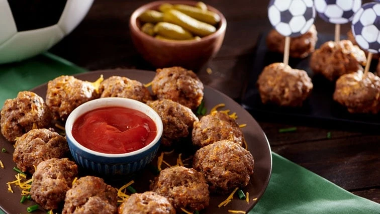 Pečené masové koule s kečupem a zeleninou.