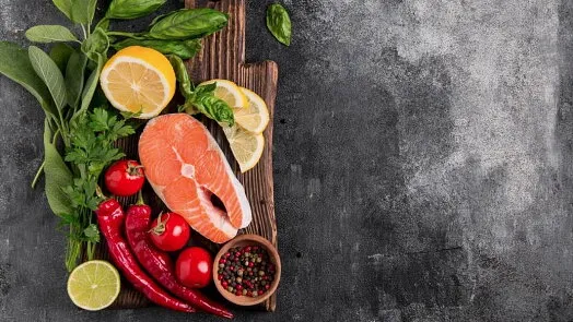 Surový losos s čerstvými ingrediencemi na dřevěném talíři.