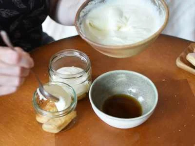 Příprava italského tiramisua s mascarpone, kávou a dámažky na dřevěném stole.