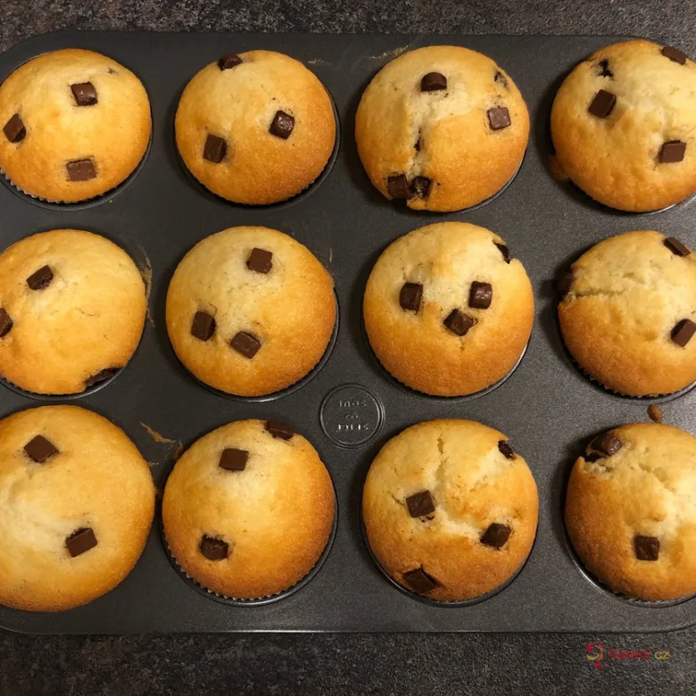 Zlatohnědé domácí muffiny s čokoládovými kousky v pekáči.