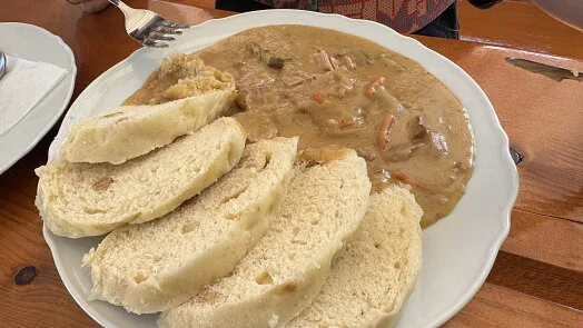 Bílý talíř s chlebem a masovou polévkou na dřeň