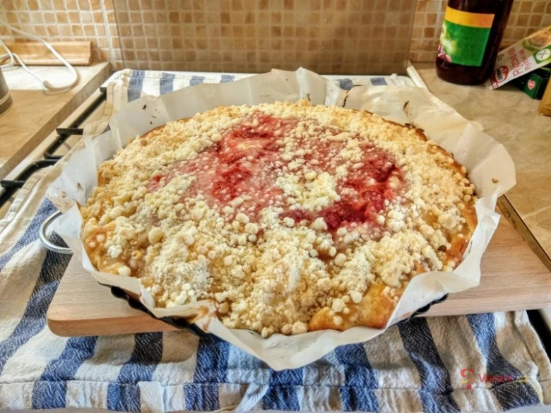 Svěží drobenkový koláč s ovocem na dřevěném prkénku.