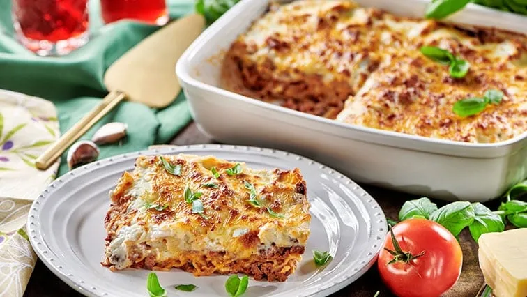 Kousek pečené lasagne z mletého masa s bazalkou.