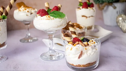 Kupky dezertu z mascarpone s jahodami, mátou a pryskyčkovými tyčkami.