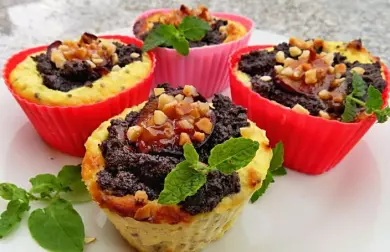 Čtyři barevné cuketové muffiny s ořechy a máta na bílém talíři.