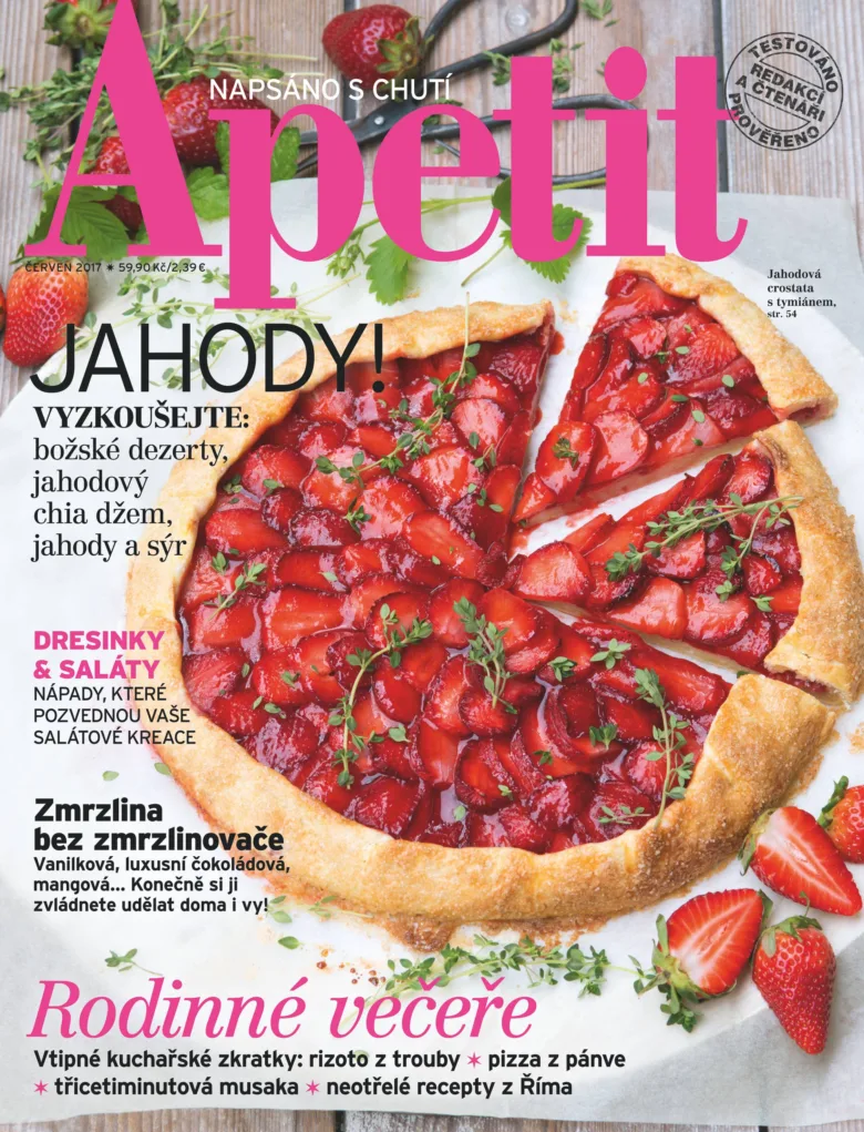 Slezený jahodový koláč s čerstvou bazalkou na dřevěném povrchu.